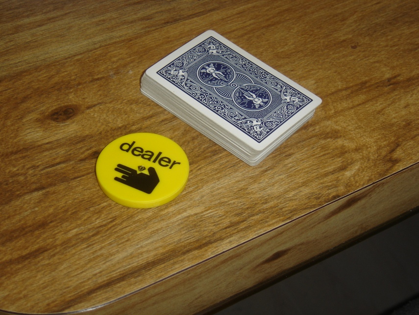 Nút dealer và bộ bài trên bàn, minh họa kiểu chơi cào cái