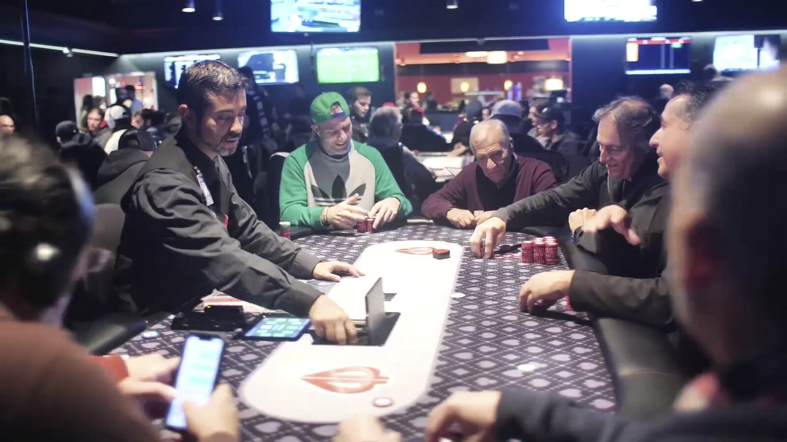 Bàn đấu poker thật với khăn trải bàn và người chơi xung quanh
